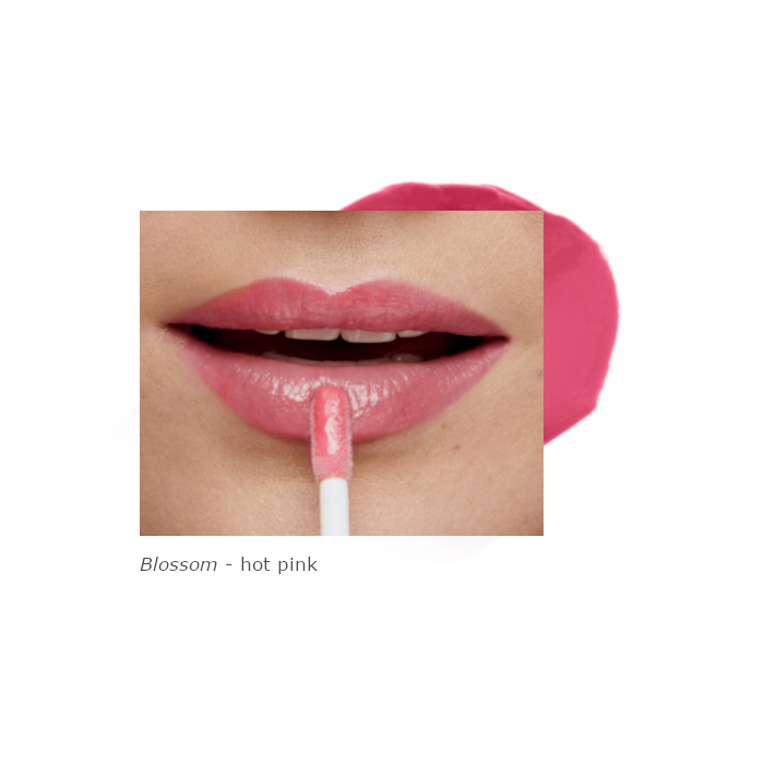 Na zdjęciu są usta modelki pomalowane odcieniem Blossom. Produkt ma intensywny, soczysty różowy kolor o kremowym wykończeniu i wysokim połysku. Formuła nadaje ustom świeżości i subtelnie je podkreśla