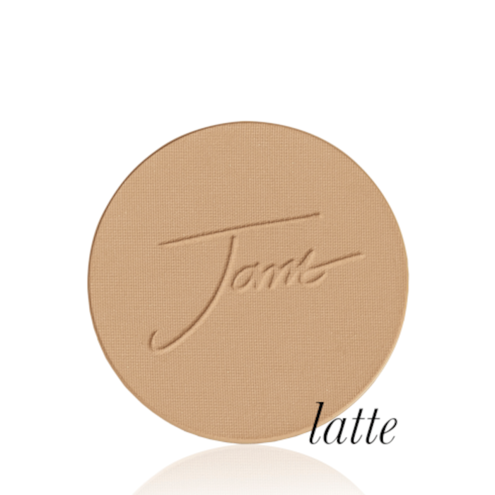 Okrągły, prasowany puder do twarzy marki Jane Iredale w odcieniu Latte: średni beż z ciepłym, karmelowym podtonem z wytłoczonym logo Jane Iredale.