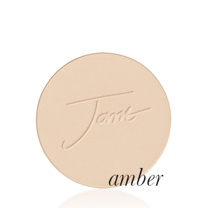 Okrągły, prasowany puder do twarzy marki Jane Iredale w odcieniu Amber - jasny do średniego beż z ciepłym, morelowo-złotym podtonem z wytłoczonym logo Jane Iredale.