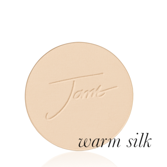 Okrągły, prasowany puder do twarzy marki Jane Iredale w odcieniu Warm Silk: Jasny beż z ciepłym, żółtym podtonem z wytłoczonym logo Jane Iredale.