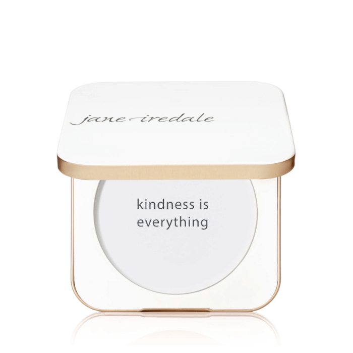 Na zdjęciu jest kompaktowe opakowanie wielokrotnego użytku marki jane iredale.  Mminimalistyczny, elegancki design w kolorze białym, napis na froncie: “you make the world more beautiful.