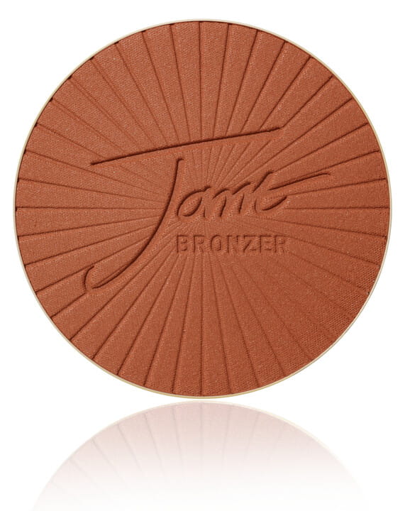 Okrągły, prasowany bronzer do twarzy marki Jane Iredale PureBronze Matte Bronzer w odcieniu DARK  z wytłoczonym logo Jane Iredale. Odcień czekoladowy brąz o głębokim, ciepłym tonie. Jest idealny dla ciemniejszych i bardzo ciemnych odcieni skóry.