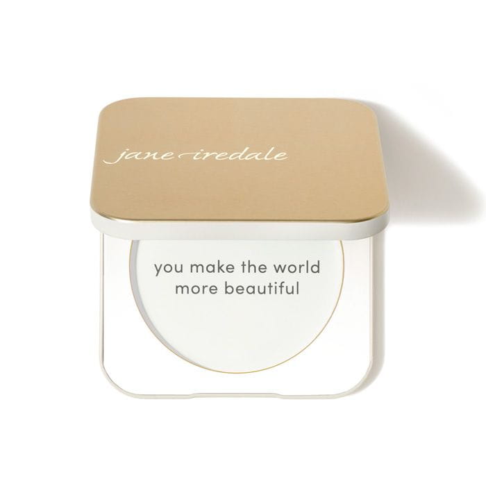 Na zdjęciu jest kompaktowe opakowanie wielokrotnego użytku marki jane iredale.  Mminimalistyczny, elegancki design w kolorze złotym i białym,  napis na froncie: “you make the world more beautiful.