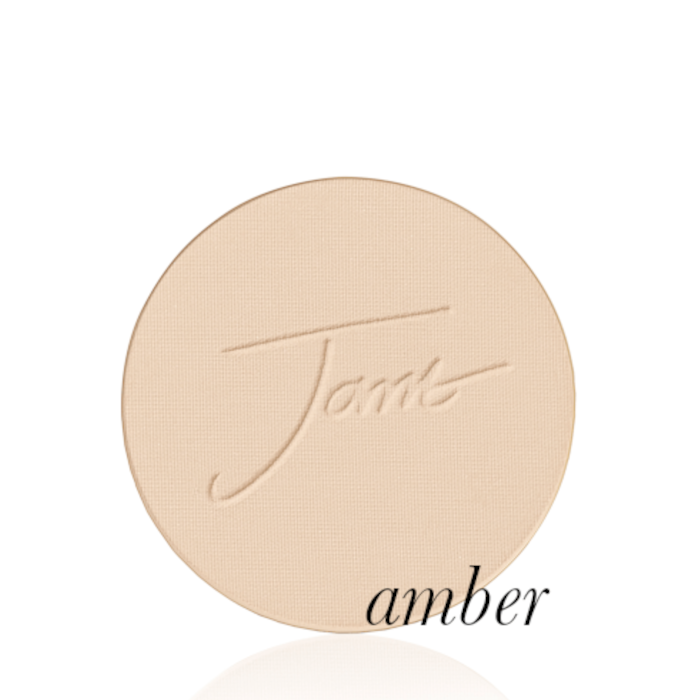 Okrągły, prasowany puder do twarzy marki Jane Iredale w odcieniu Amber - jasny do średniego beż z ciepłym, morelowo-złotym podtonem z wytłoczonym logo Jane Iredale.