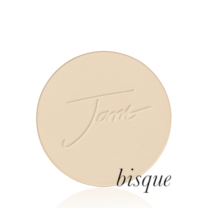 Okrągły, prasowany puder do twarzy marki Jane Iredale w odcieniu Bisque: bardzo jasny odcień kości słoniowej z ciepłym, kremowym podtonem z wytłoczonym logo Jane Iredale.