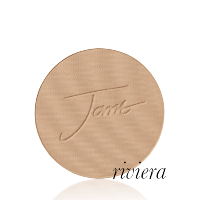 Okrągły, prasowany puder do twarzy marki Jane Iredale w odcieniu Riviera: średni do ciemniejszego beż z ciepłym, złocisto-brązowym podtonem z wytłoczonym logo Jane Iredale.