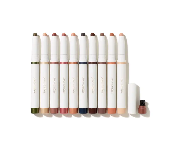 Na zdjęciu znajduje się zestaw kredek w sztyfcie jane iredale, przeznaczonych do makijażu oczu – są to cienie do powiek eyeshadow stick.  Wszystkie produkty mają jednolite, białe opakowania z złotym napisem.