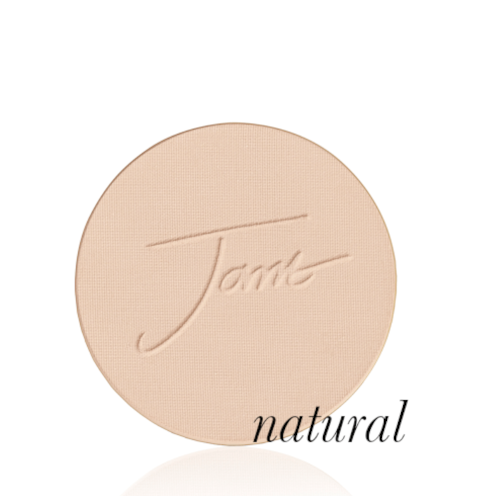 Okrągły, prasowany puder do twarzy marki Jane Iredale w odcieniu Natural: jasny beż z delikatnie złocistym, neutralnym podtonem z wytłoczonym logo Jane Iredale.