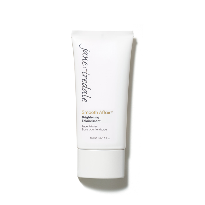 Na zdjęciu znajduje się biała tubka bazy pod makijaż Jane Iredale Smooth Affair Brightening Face Primer. Na niej czarno – złote napisy z nazwą produktu. Produkt rozświetla i wygładza skórę i przygotowuje ją do aplikacji makijażu.