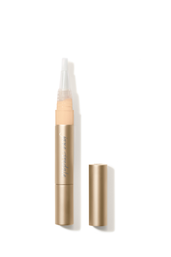 Na zdjęciu znajduje jedna sztuka korektora rozświetlającego Active Light marki Jane Iredale. Produkt ma eleganckie, złote opakowanie w formie pisaka z pędzelkowym aplikatorem. Dostępny jest w różnych odcieniach, dopasowanych do karnacji.