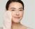 Na zdjęciu jest kobieta używającą rękawicy Magic Mitt marki Jane Iredale do oczyszczania twarzy. Kobieta wygląda na zrelaksowaną i zadowoloną, a jej cera jest promienna i świeża.