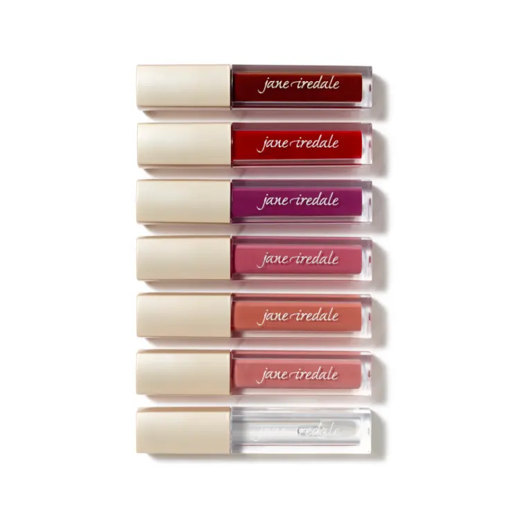 Na zdjęciu znajduje się zestaw błyszczyków Lip Glaze marki Jane Iredale. Produkty ułożone są pionowo, jeden nad drugim, w eleganckich opakowaniach z beżową nakrętką i przezroczystym korpusem, przez który widać kolor błyszczyka.