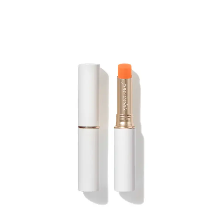 Na zdjęciu widoczna jest pomadka z kolekcji Just Kissed Lip and Cheek Stain marki Jane Iredale. Produkt umieszczony jest w eleganckim, białym opakowaniu ze złotym wykończeniem.