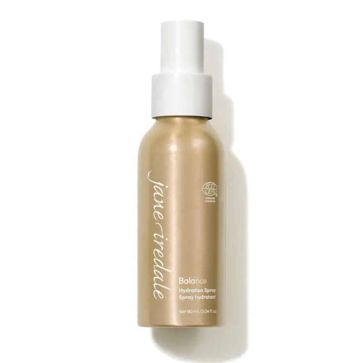Na zdjęciu znajduje się elegancka złota butelka z białym atomizerem wody Jane Iredale  Balance Hydration Spray o pojemności 90 ml. Produkt posiada oznaczenie ECOCERT co potwierdza jego organiczne i naturalne pochodzenie składników.