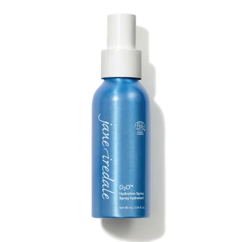 Na zdjęciu znajduje się elegancka niebieska butelka z białym atomizerem wody Jane Iredale D2O Hydration Spray o pojemności 90 ml. Produkt posiada oznaczenie ECOCERT co potwierdza jego organiczne i naturalne pochodzenie składników.