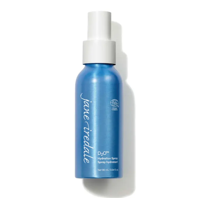 Na zdjęciu znajduje się elegancka niebieska butelka z białym atomizerem wody Jane Iredale D2O Hydration Spray o pojemności 90 ml. Produkt posiada oznaczenie ECOCERT co potwierdza jego organiczne i naturalne pochodzenie składników.