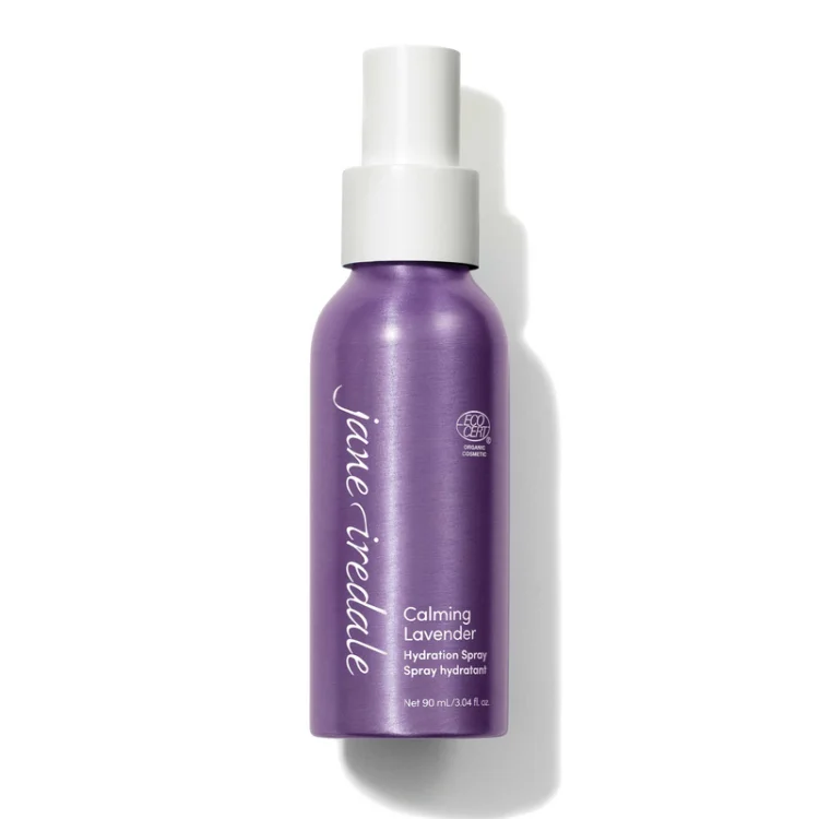 Na zdjęciu znajduje się elegancka, fioletowa butelka z białym atomizerem wody Jane Iredale Lavender Hydration Spray o pojemności 90 ml. Produkt posiada oznaczenie ECOCERT co potwierdza jego organiczne i naturalne pochodzenie składników.