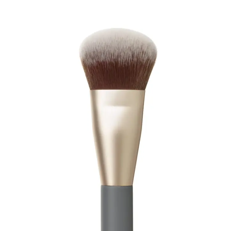 Na zdjęciu jest zbliżenie na włosie pędzla do makijażu marki jane iredale. Ma lekko skośnie ścięte, gęste i puszyste włosie w odcieniach brązu i bieli oraz ciemny trzonek.