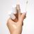 Na zdjęciu widać dłoń trzymającą trzy korektory PureMatch Liquid Concealer w różnych odcieniach. Jeden z korektorów ma odkręconą nakrętkę i aplikator z gąbeczką. Na wierzchu dłoni znajdują się próbki kolorów – jeden bardzo jasny, drugi bardziej beżowy.