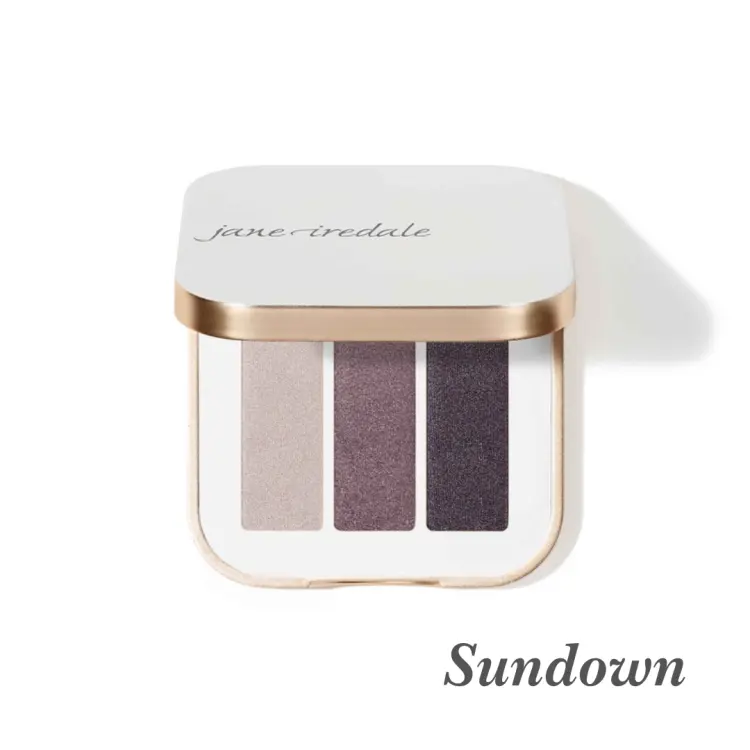 Na zdjęciu jest potrójna paletka cieni do powiek Jane Iredale w odcieniu Sundown. Zawiera trzy odcienie o chłodnej, wieczorowej tonacji: połyskujący taupe (szarobrązowy), chłodna, śliwkowa tonacja z błyskiem, intensywny grafitowy cień z połyskiem
