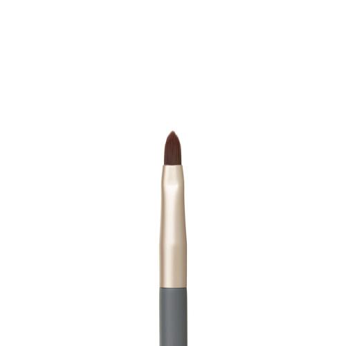 Na zdjęciu jest zbliżenie na pędzelek do ust z kolekcji jane iredale. Ma precyzyjny, spiczasty kształt włosia, który umożliwia dokładne obrysowanie konturu ust i równomierne wypełnienie ich kolorem.