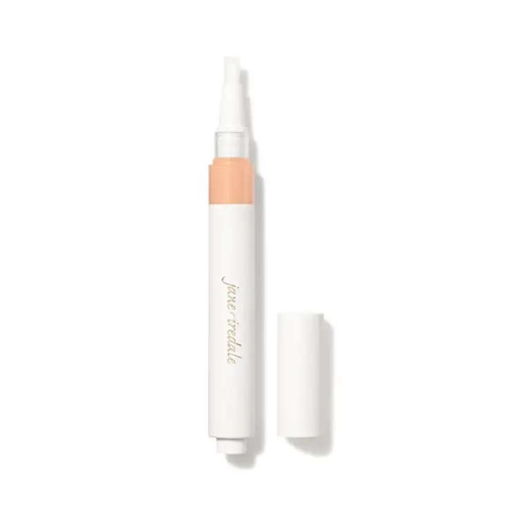 Na zdjęciu znajduje się korektor w pędzelku marki jane iredale – Skintuition Brightening Under Eye Concealer. Widać opakowanie typu twist z wbudowanym aplikatorem-pędzelkiem oraz zatyczkę. Produkt służy do rozświetlania i maskowania cieni pod oczami.
