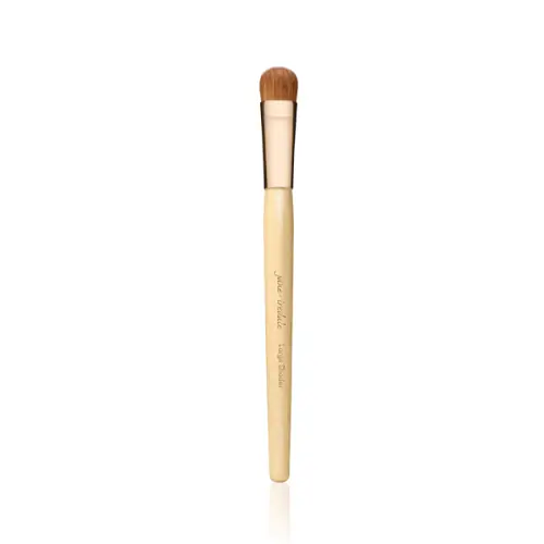 Large Shader Brush Jane Iredale - szeroki, płaski pędzel do cieni z miękkim włosiem Naturon, jasnym trzonkiem i złotą skuwką.